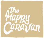 The Happy Caravan staked logo in sand